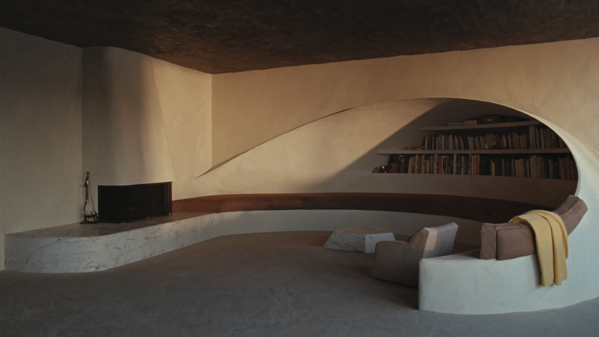 A curved plaster snug wrapping a low fireplace, warm Grisons winter light